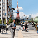 A male student that is standing in the middle of a city
