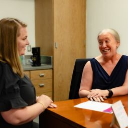 two people talking at a desk