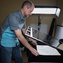 man adjusting map of South Carolina under glass.