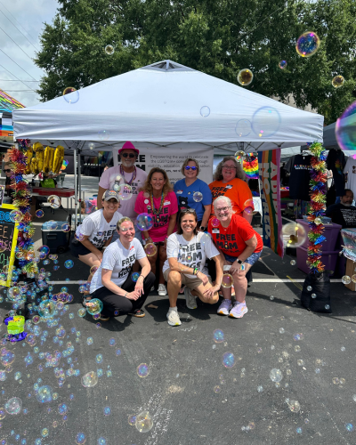 members of Free Mom Hugs at an outdoor event smiling and surrounded by bubbles