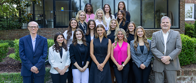 The Department of Retailing Student Advisory Board stands together for a group photo outside.