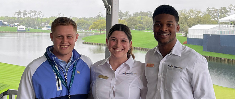Three students pose for a photo while working the 2022 Players Championship.