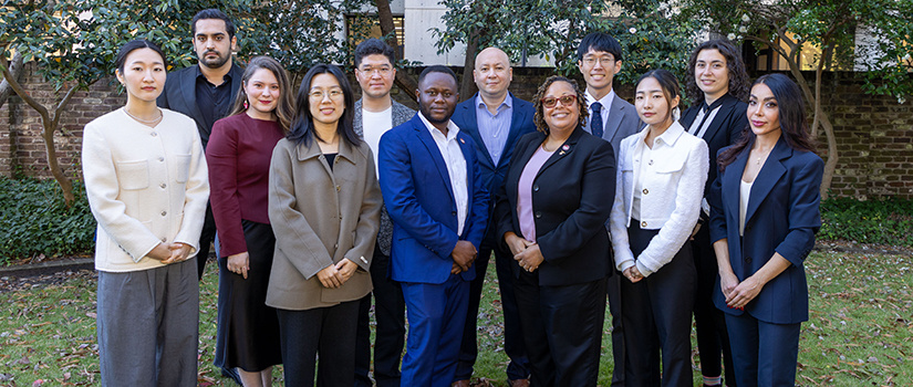 Members of the Ph.D. in hospitality management program pose for a photo in a garden.