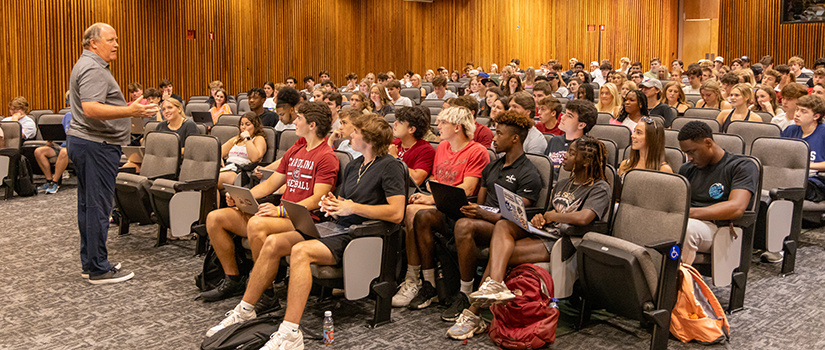 Students in a lecture hall listening to a professor