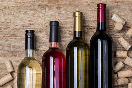 Four bottles of wine lying down on a table