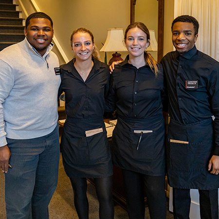 Four students pose for a photo at McCutchen House.