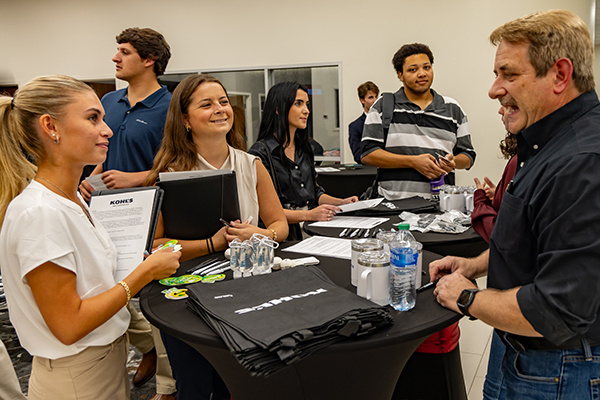 Two students visit with a Kohl's representative