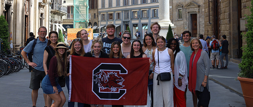 Faculty and staff pose with students in Italy