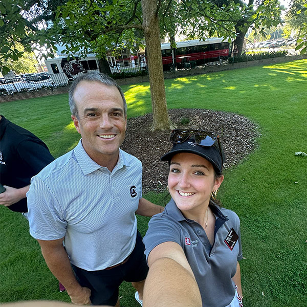 Abby Tabachini stands on the Horseshoe with football coach Shane Beamer