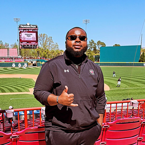 Jaron Coney gives a spurs up sign at Founders Park baseball field.