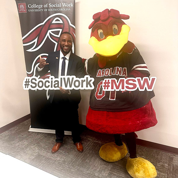 Kai Ivery stands with Cocky