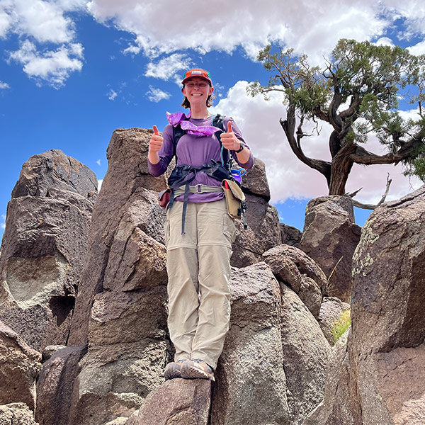 Laura Doughton stands among rocks in the Rocky Mountains.