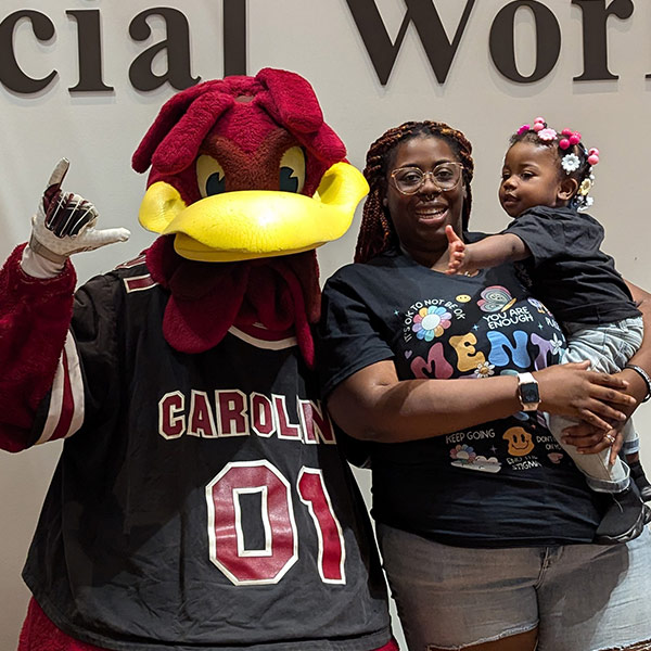 Mysticka Robinson holds her daughter, standing next to Cocky