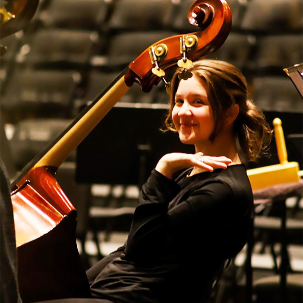 Katheryn Ailes sits with her instrument in the USC Symphony Orchestra.