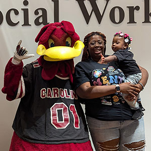 Mysticka Robinson holds her daughter, standin next to Cocky